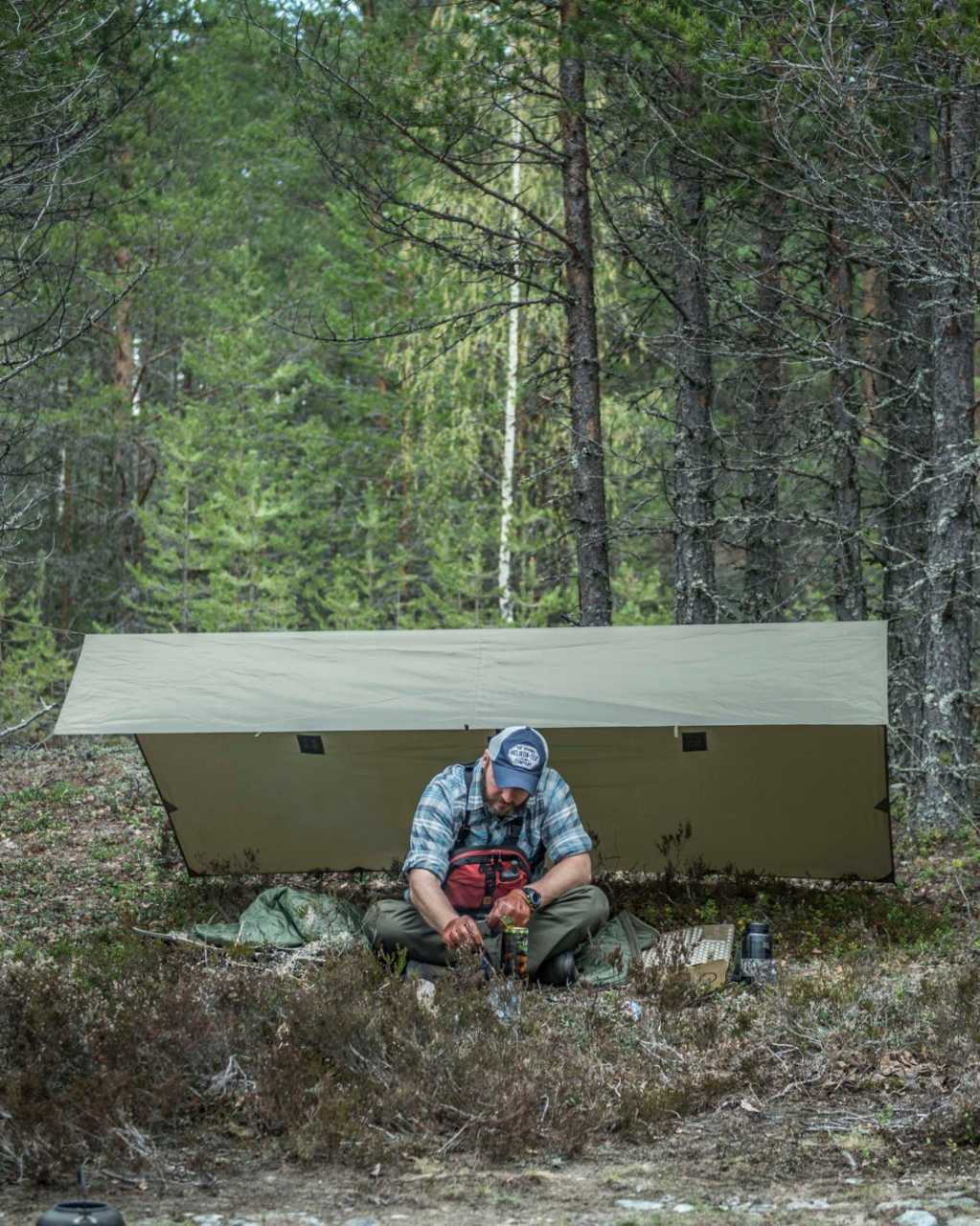 Outdoor-Camp mit Tarp und Ausrüstung im Wald